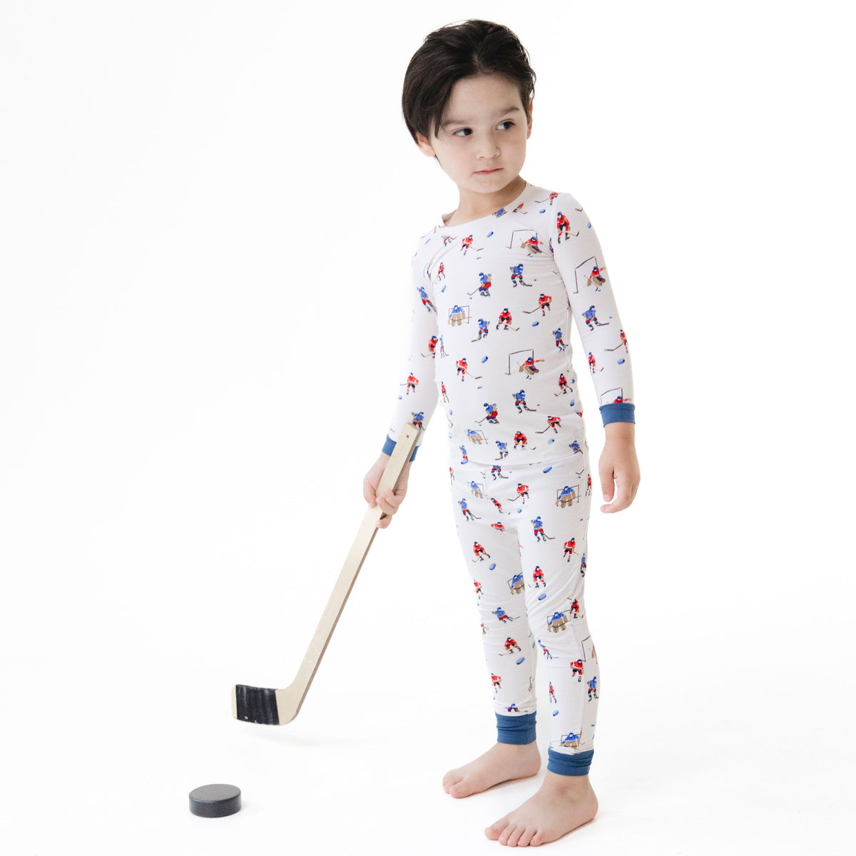 Two-piece baby loungewear set with long sleeve top and pants in a hockey players print