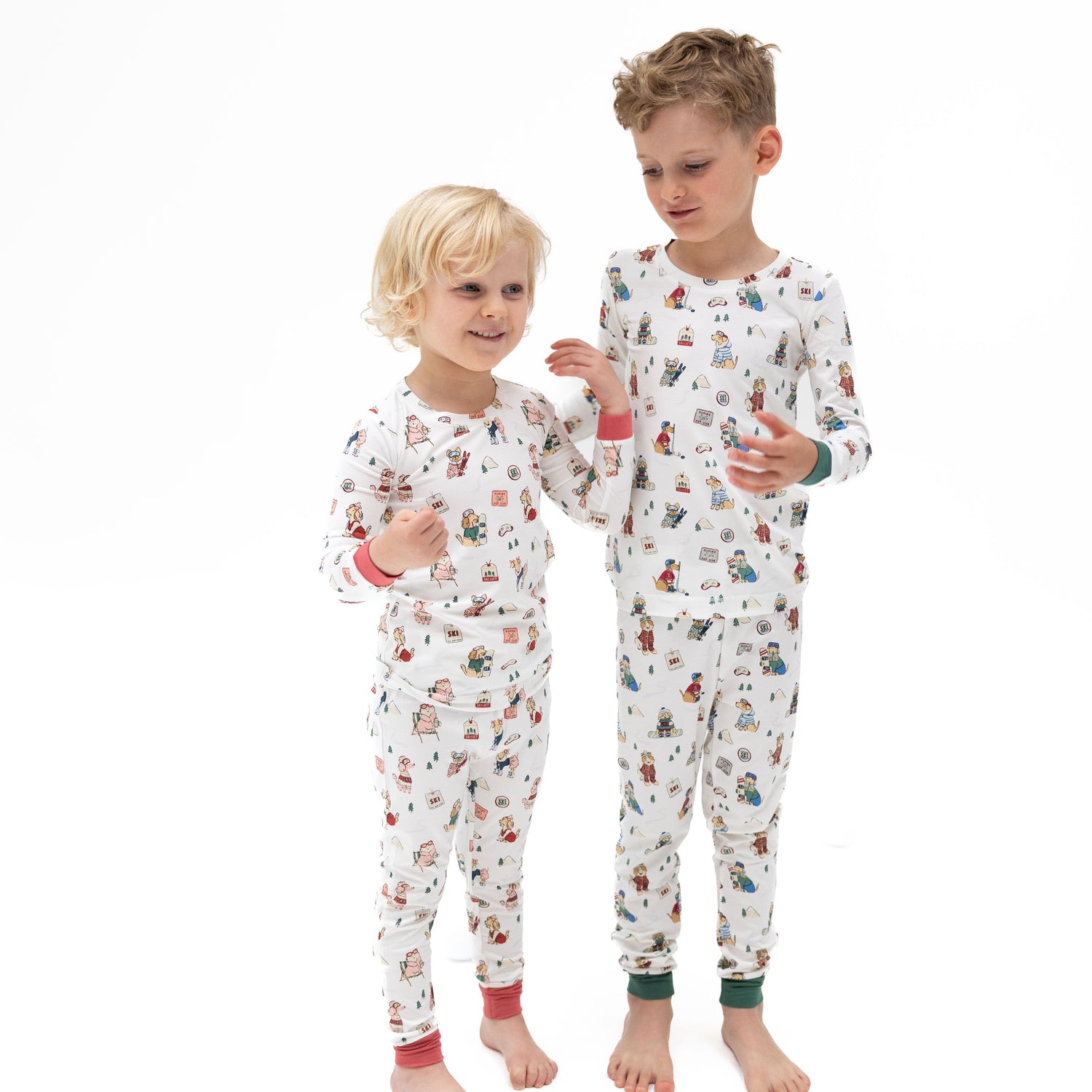 Pink two-piece long sleeve loungewear set with a winter sports dogs print on the top and pants.