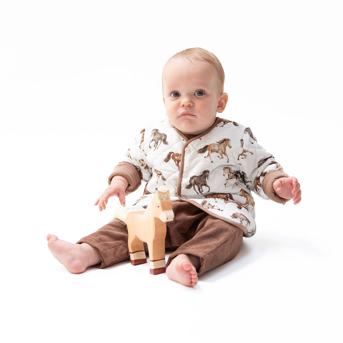 Quilted V-neck baby jacket in Wild Horses print with two front pockets