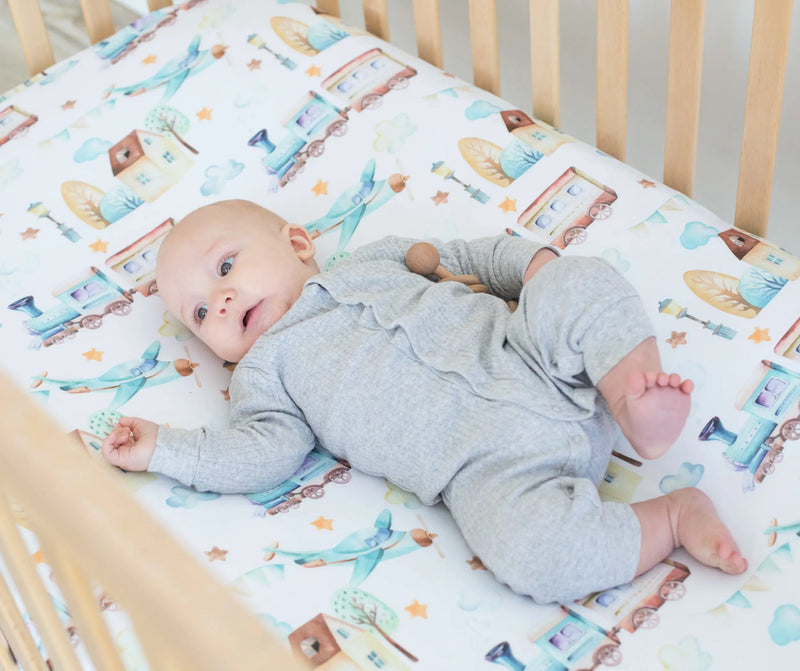 Fitted Crib Sheet with Airplane and Train Pattern in Crib with Baby.