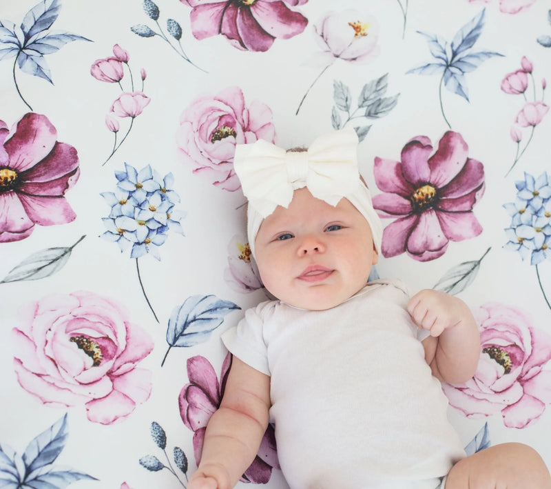 Vintage floral fitted crib sheet with baby on soft, colorful floral design.