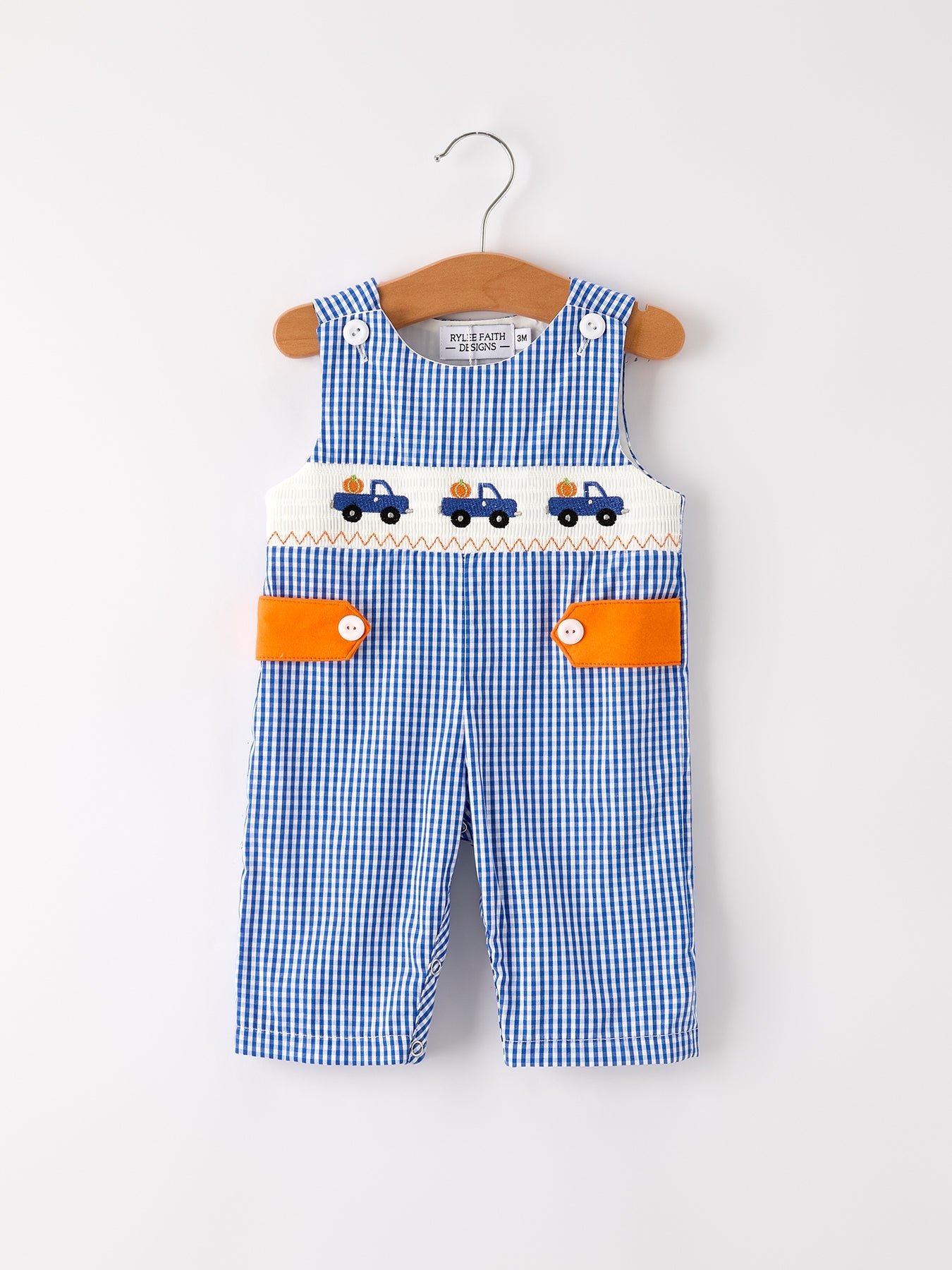 Baby boy romper in fall colors with a truck smock embroidery design across the front.