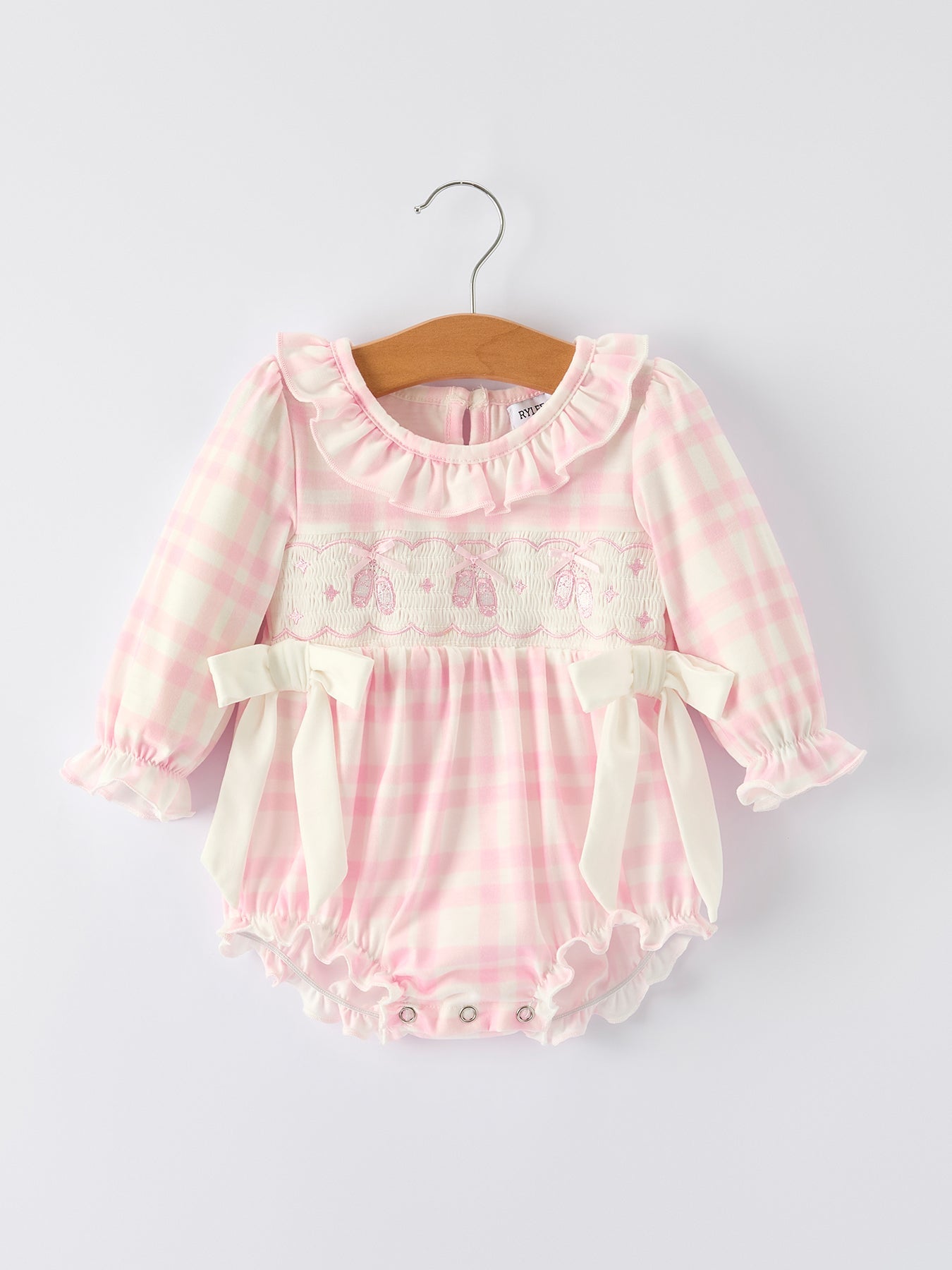 Pink plaid long sleeve baby romper with ballet shoe embroidery and ruffled accents.