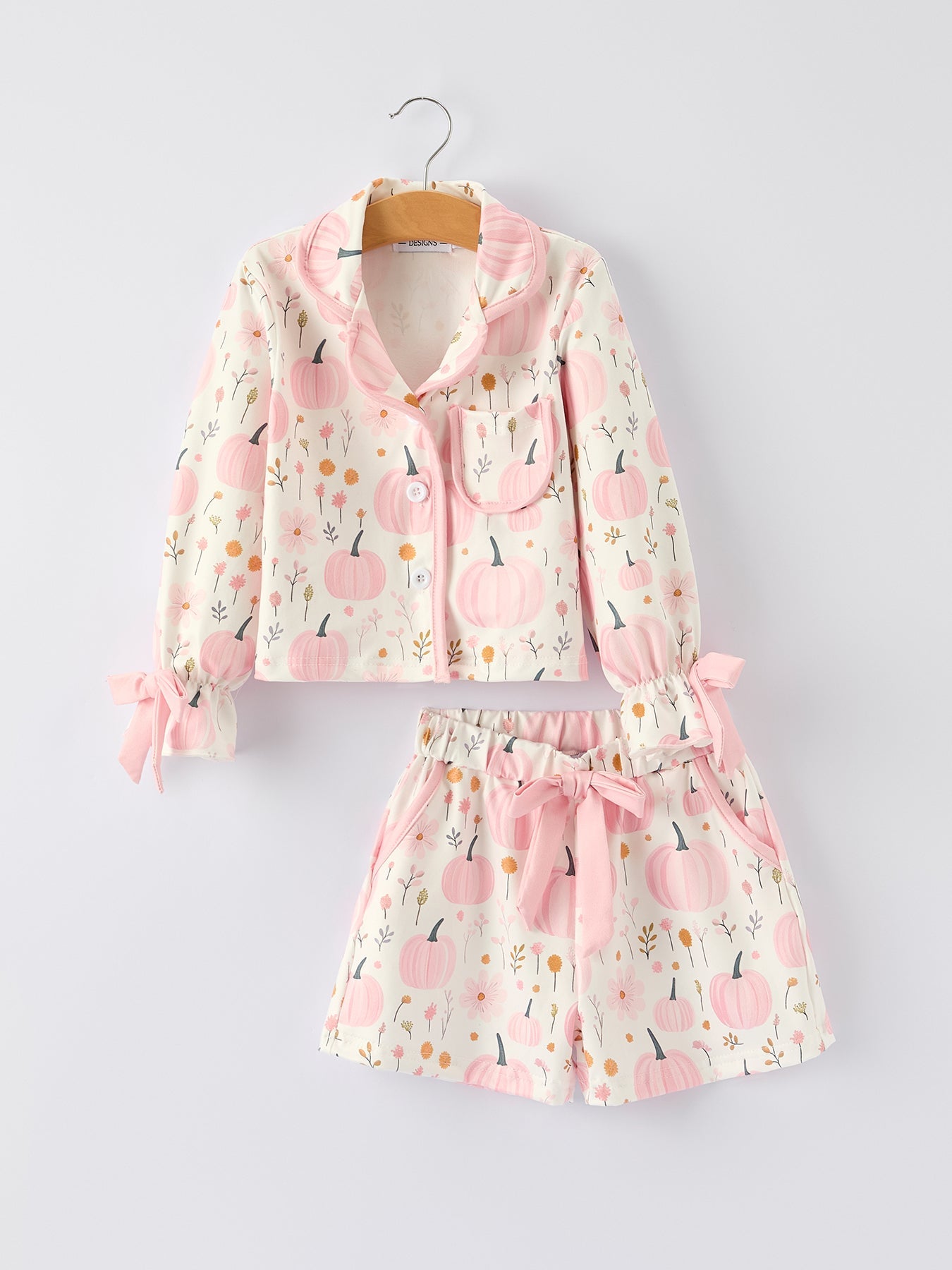 Two-piece pajama set with pink pumpkin and floral print on a light background