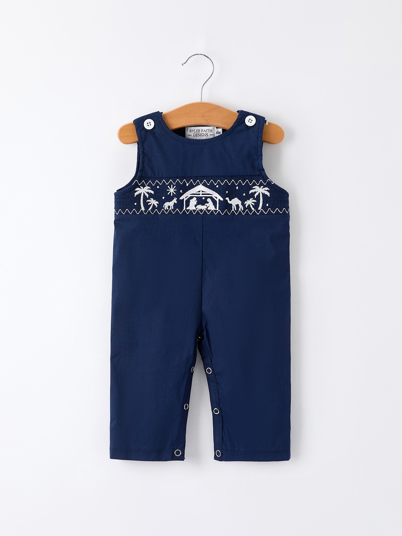 Navy blue baby boy romper with smocking detail and embroidered nativity scene across the chest