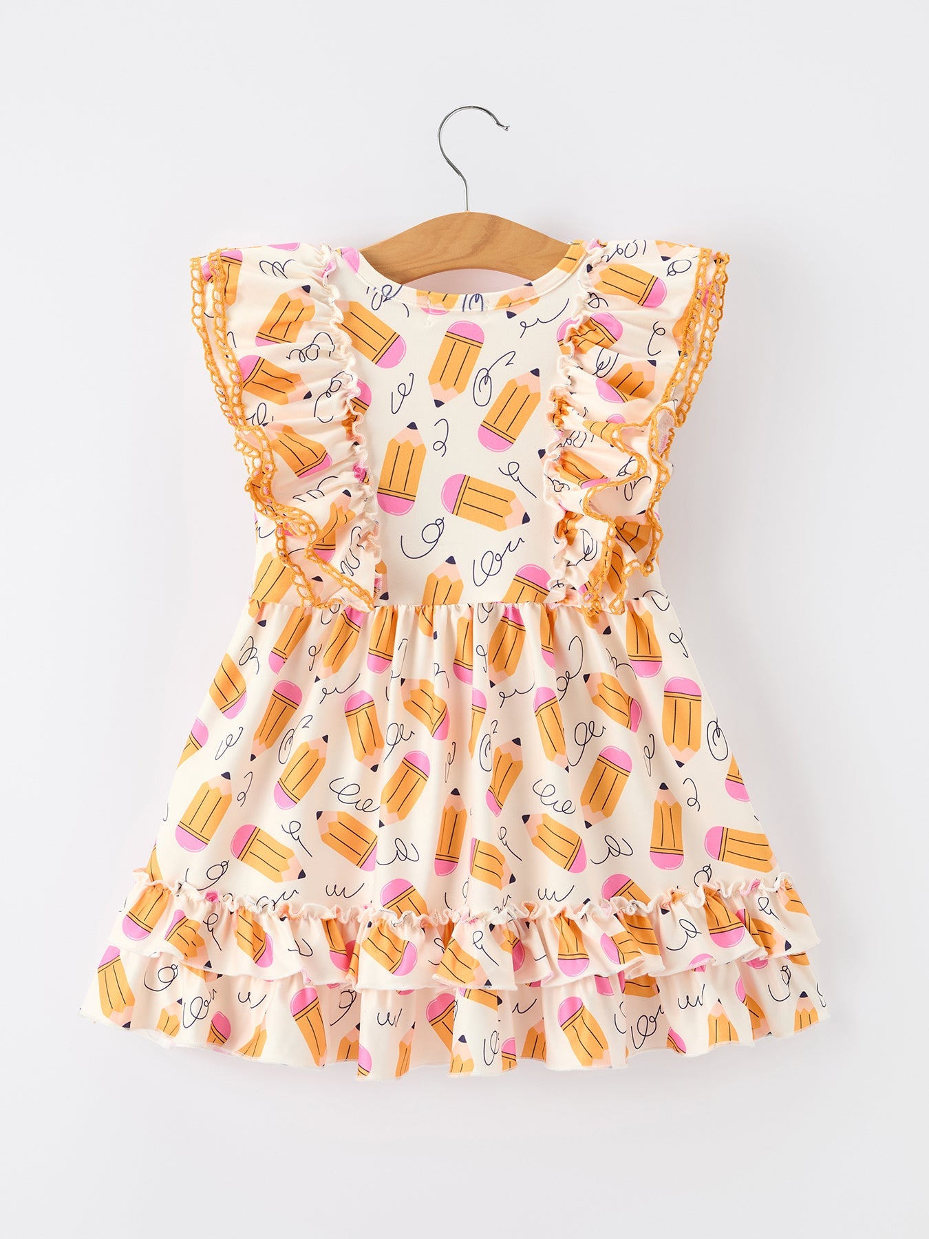 Young girl wearing a white twirl dress with colorful pencil print and flutter sleeves, smiling.