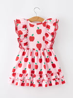 Girl wearing Rylee Faith Designs apple print twirl dress with flutter sleeves, playing happily.