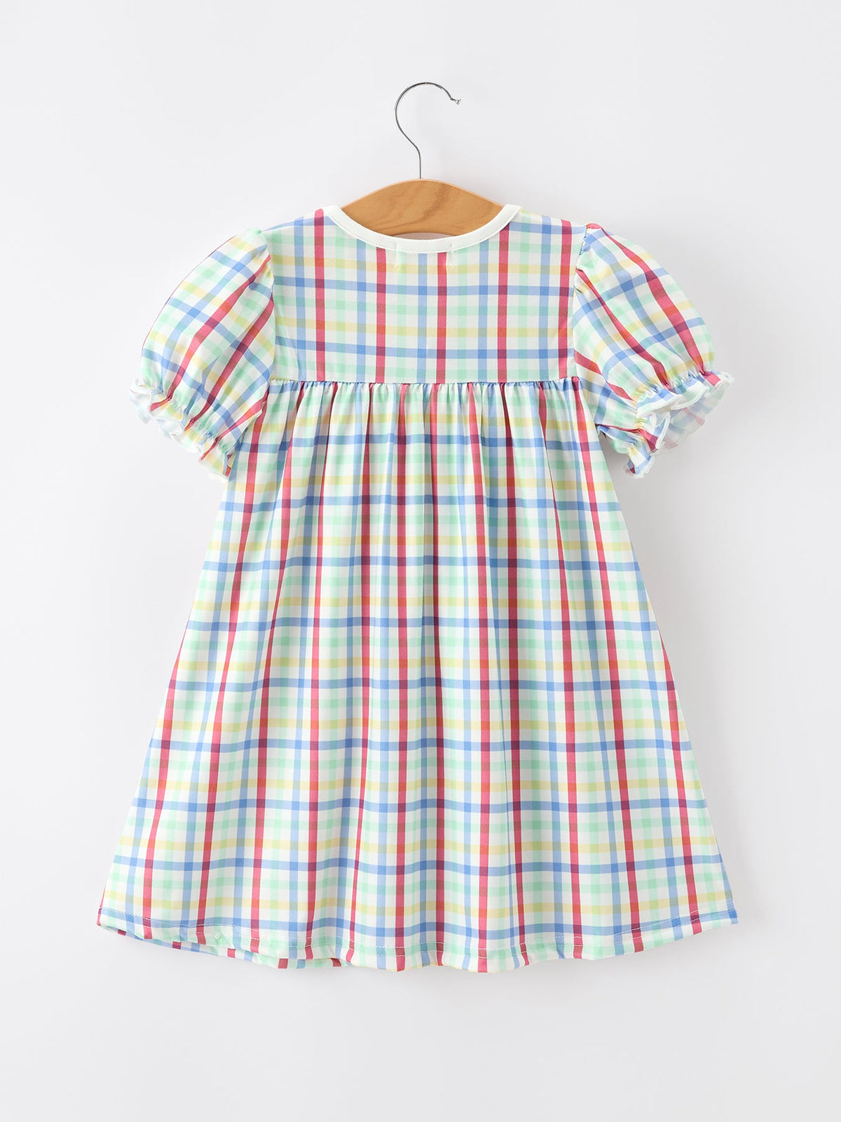 Young girl wearing a Rylee Faith Designs plaid dog print twirl dress, perfect for back to school.