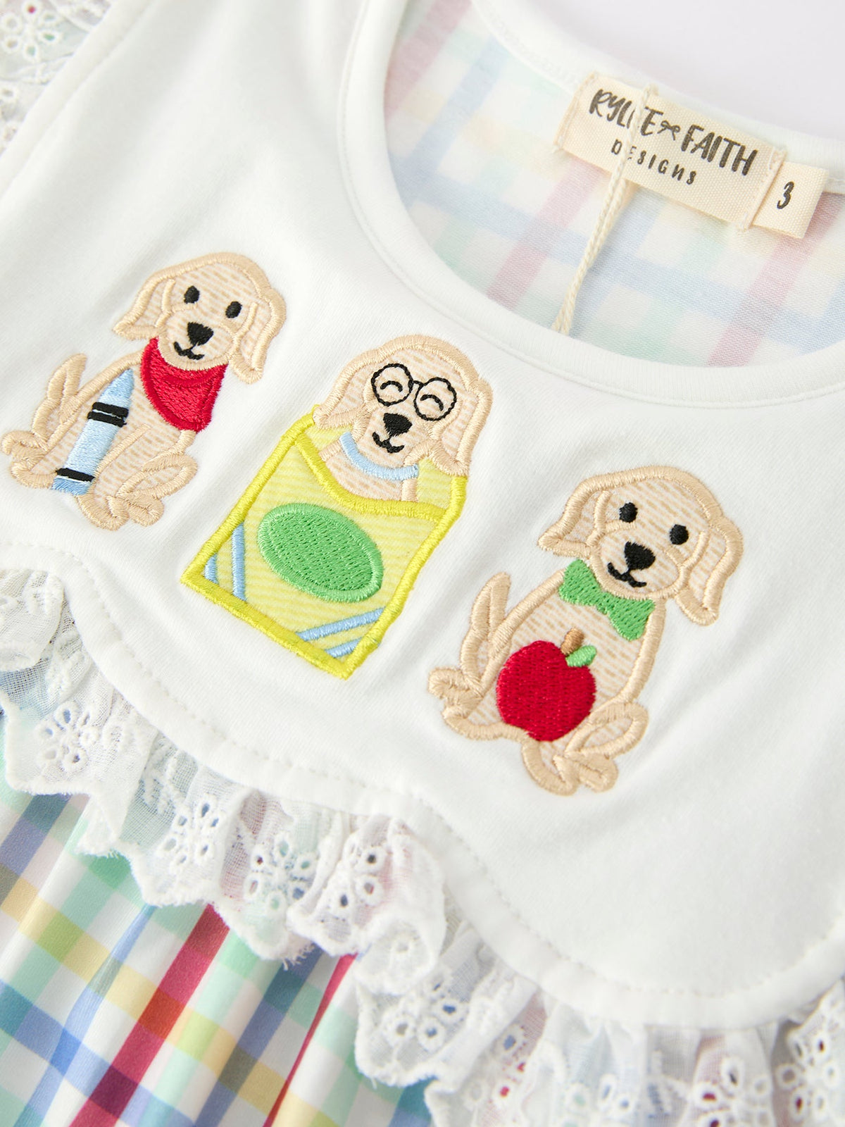 Young girl wearing a Rylee Faith Designs plaid dog print twirl dress, perfect for back to school.