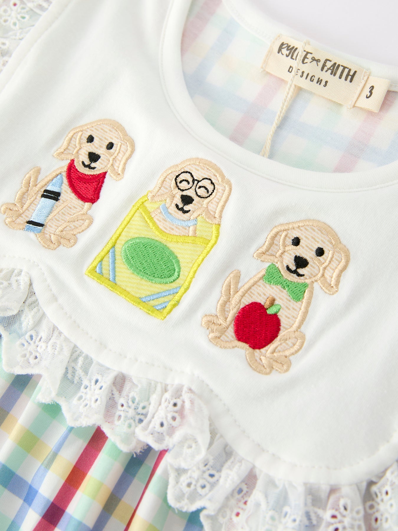 Young girl wearing a Rylee Faith Designs plaid dog print twirl dress, perfect for back to school.