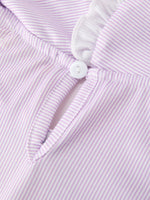 Young girl wearing a purple dress with a pencil applique, petals collar, and ruffled hem.