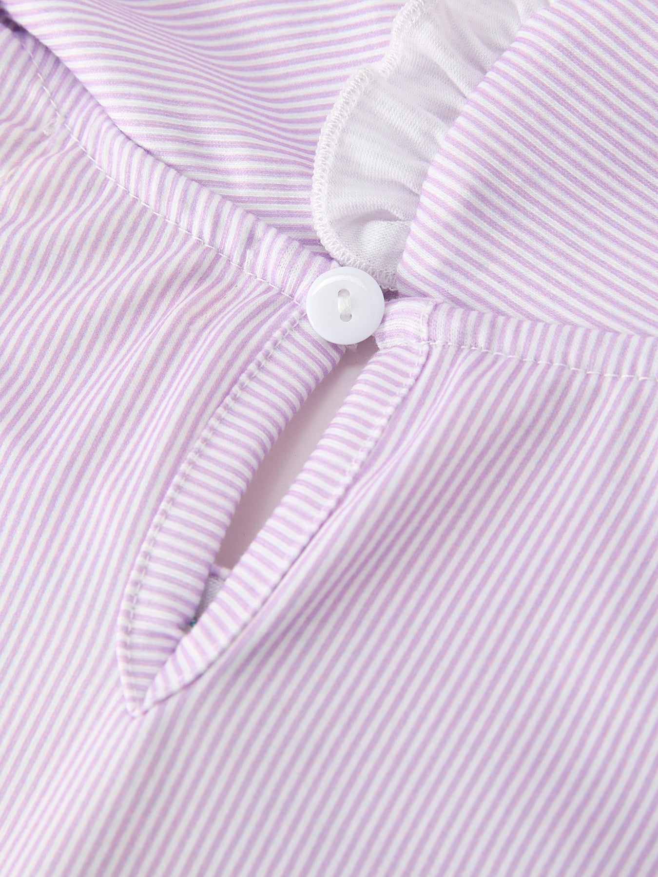 Young girl wearing a purple dress with a pencil applique, petals collar, and ruffled hem.