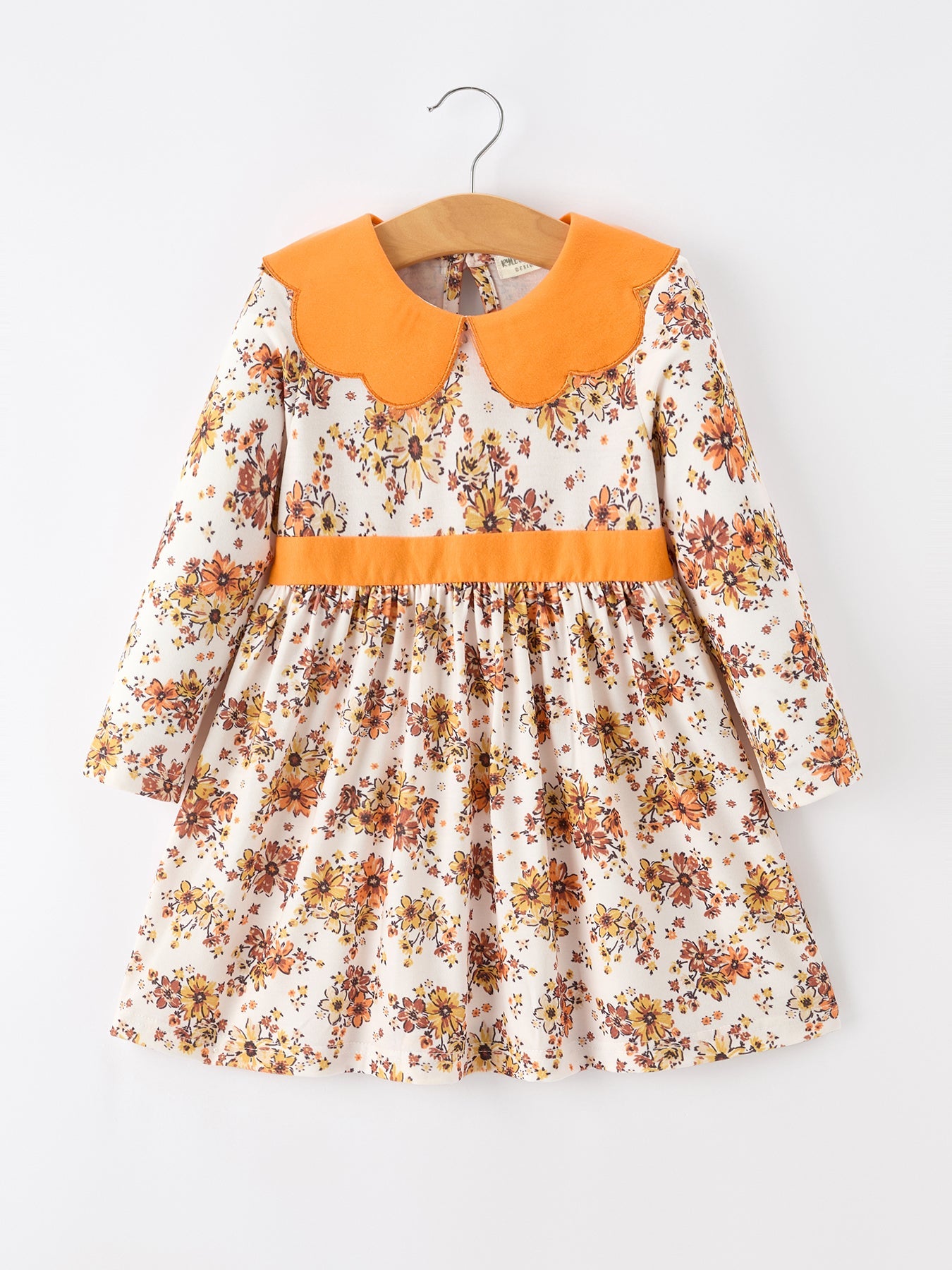 Girl's dress in orange floral print with a contrasting orange petals collar and gathered flowy skirt.