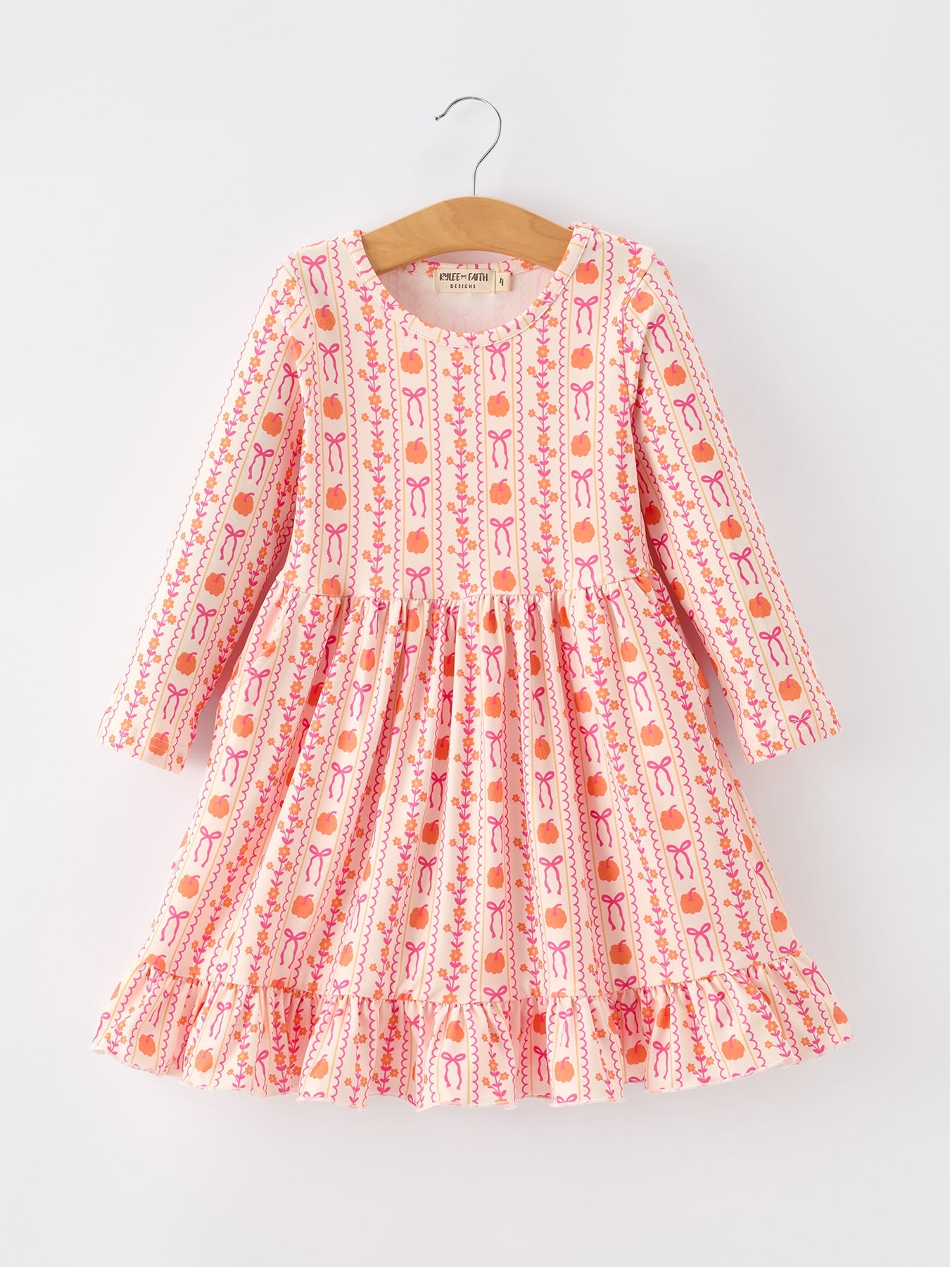 Long-sleeve girls dress with pumpkin and bow stripe print, ruffle hem, and side pockets