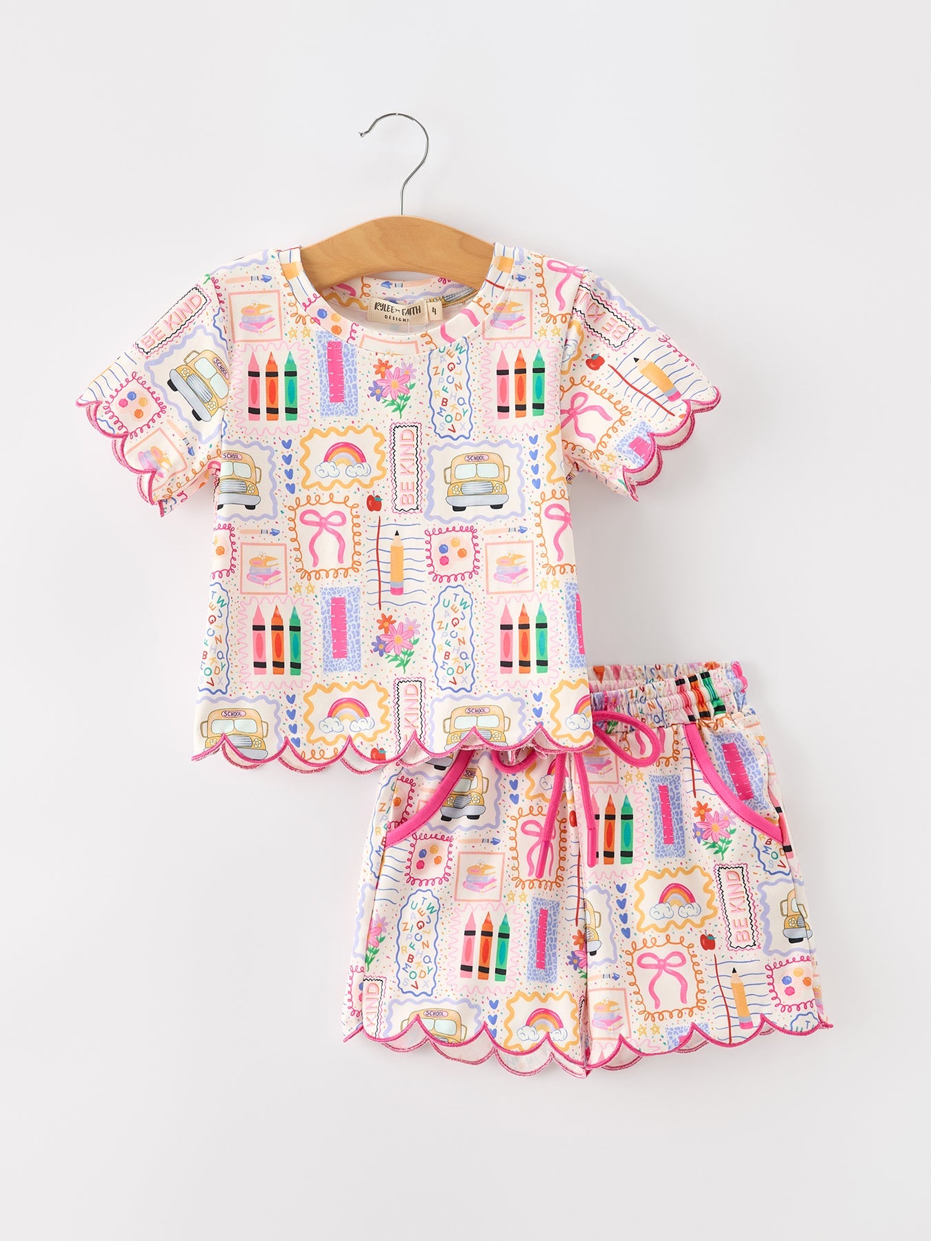 Girls' two-piece short set in a back-to-school print with school buses, crayons, pencils, bows, and rainbows and a scallop