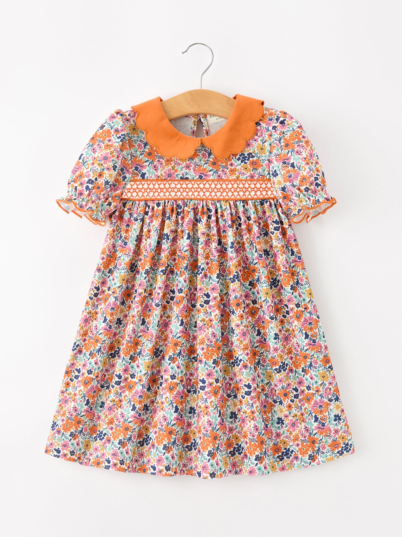 Girls dress with colorful floral print, puff sleeves, smocked bodice, and a contrasting petals collar.
