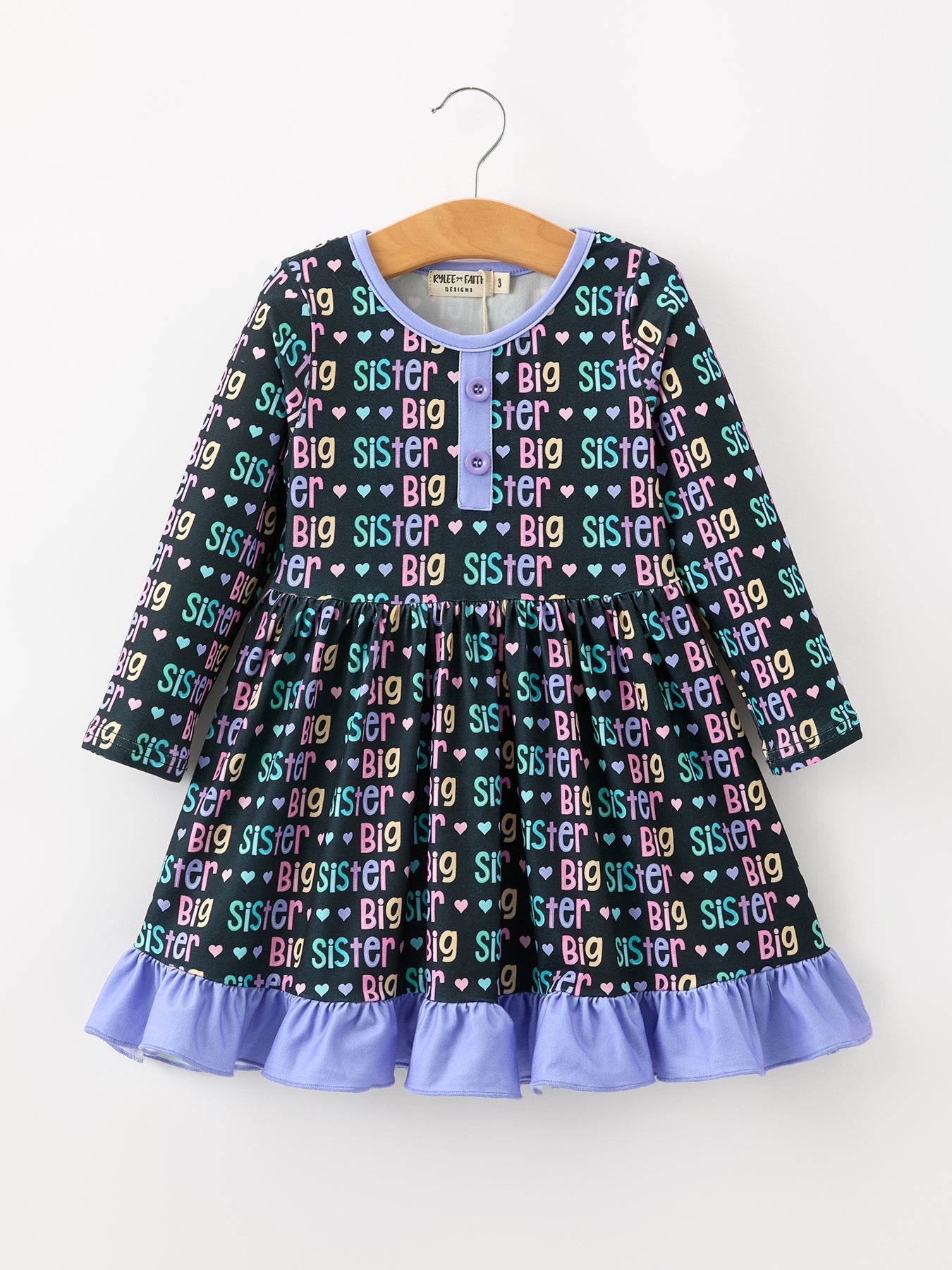 Girls dress with rainbow "Big Sister" lettering print and a ruffle hem
