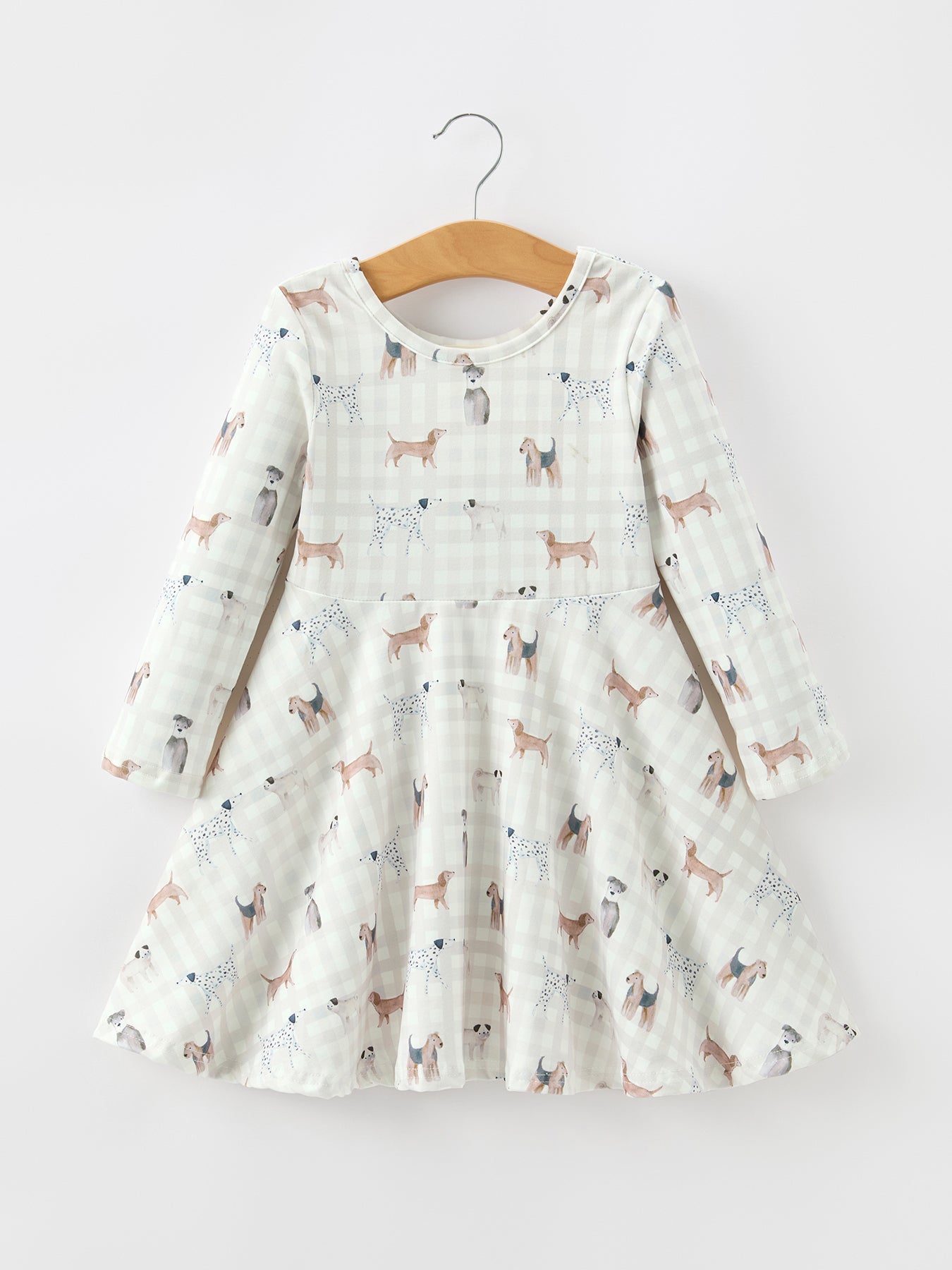 Long sleeve twirl dress in neutral plaid with dog illustrations and a flowy full skirt.