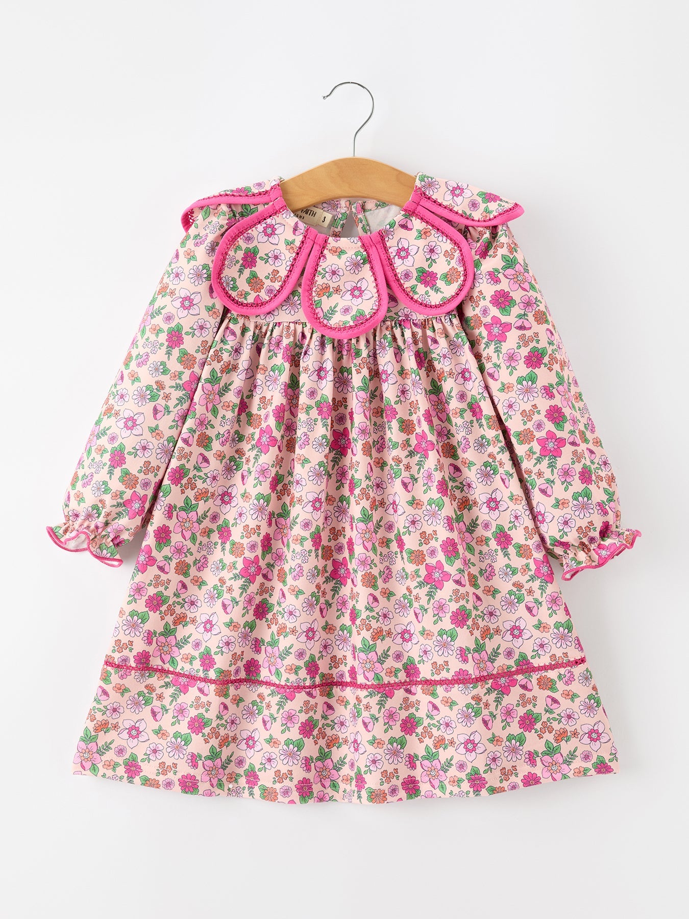 Long-sleeve girl's dress with soft floral print and bright hot pink petal-shaped collar accents.