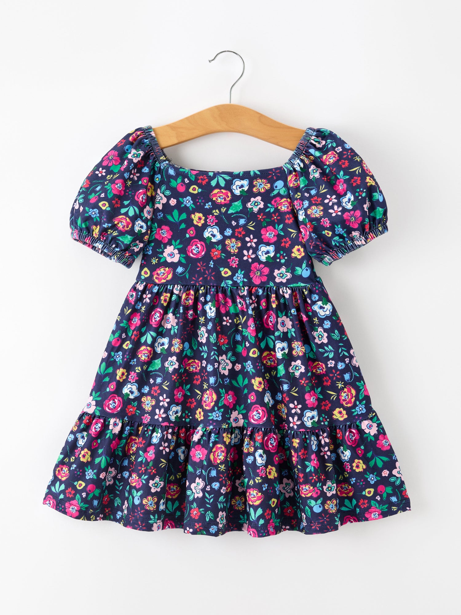 Girls dress with colorful wildflower print, puff sleeves, square neckline, gathered waist, and flowy skirt