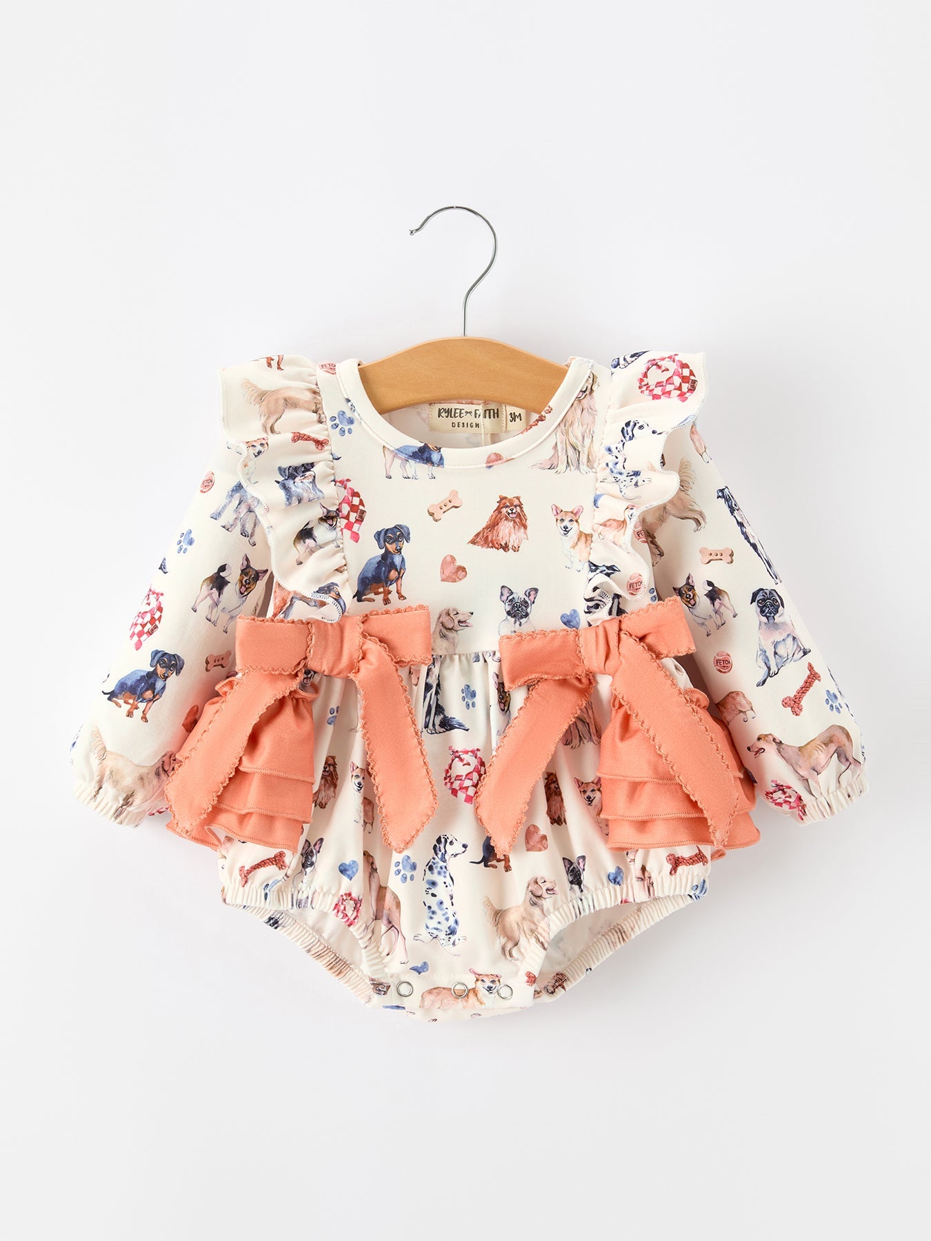 Long sleeve girls romper with fall dog print, layered ruffles, and oversized bow accents.