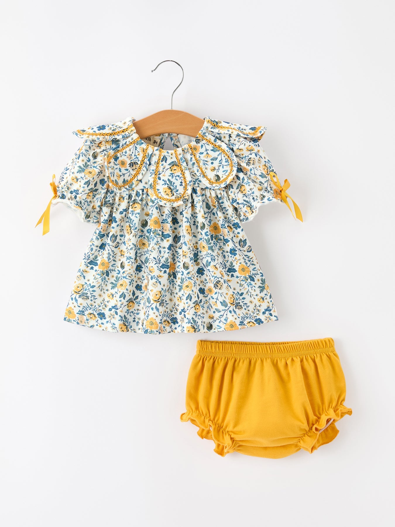 Girls' outfit set with blue and yellow floral puff-sleeve top and matching mustard yellow ruffle-leg bloomers.