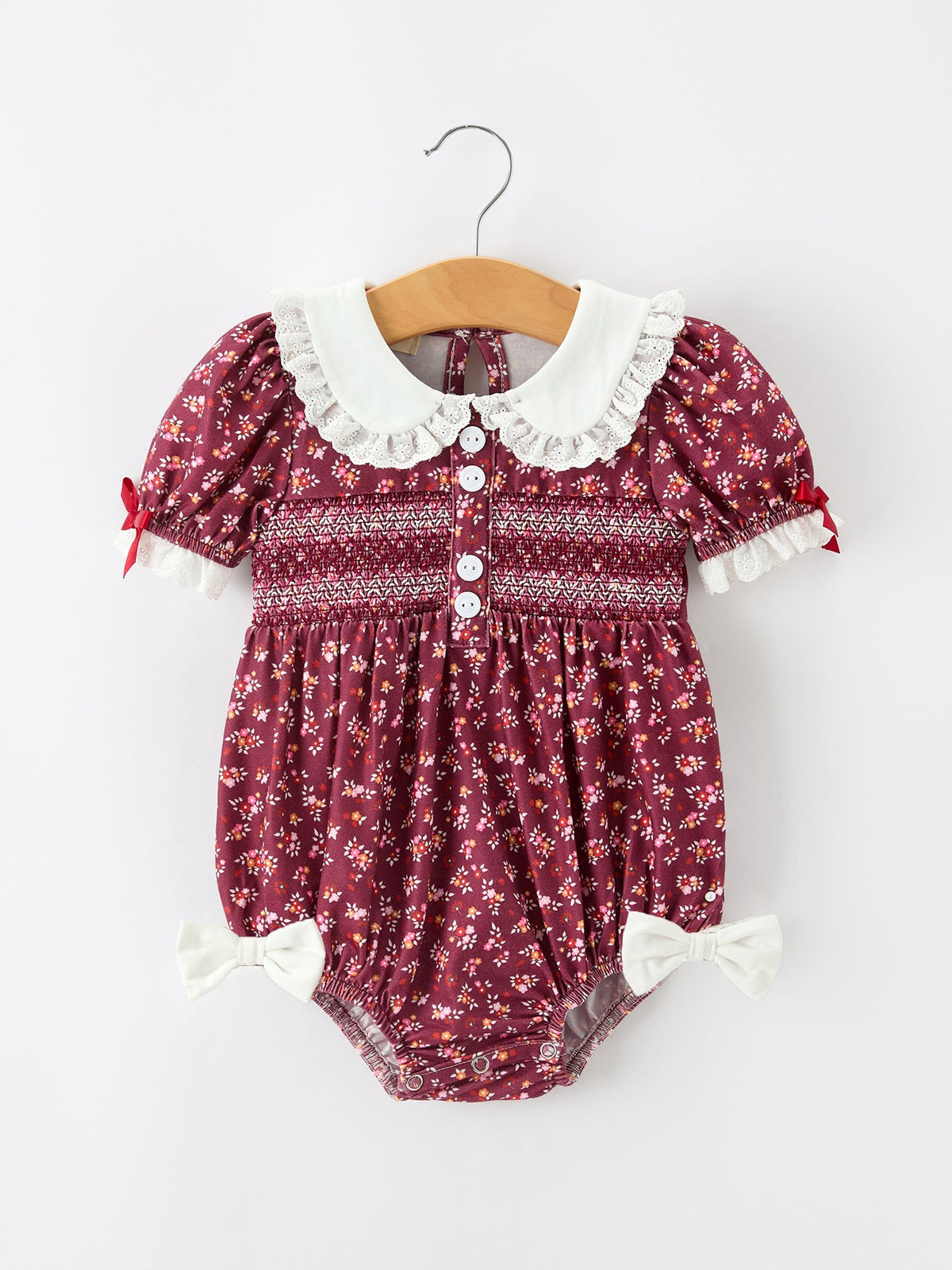 Baby girl bubble romper with floral print, smocked chest, Peter Pan collar, puff sleeves, and lace trim
