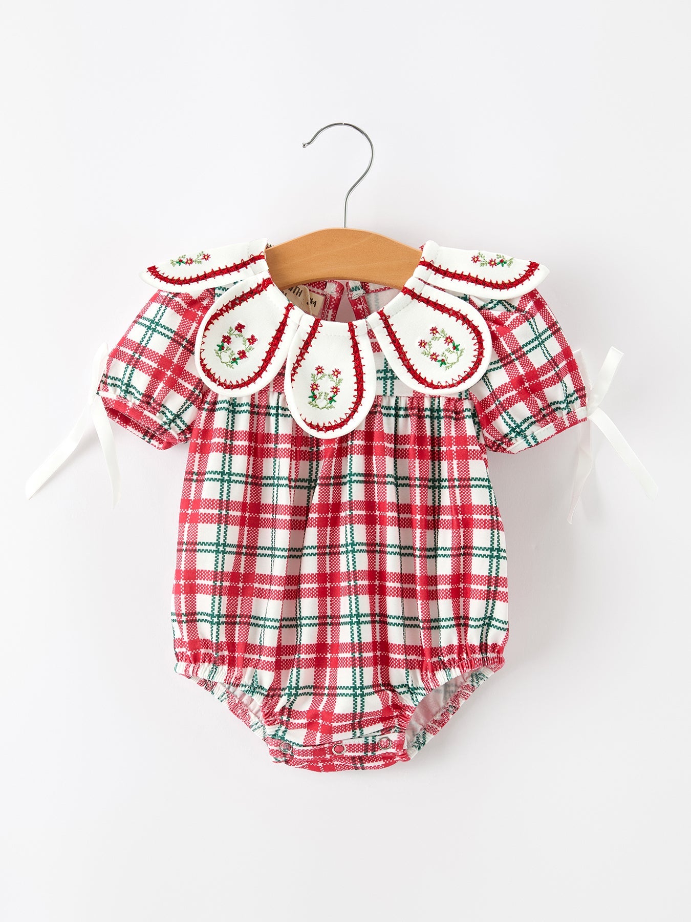 Baby girl bubble romper in red and green Christmas plaid with an embroidered wreath collar and holly details