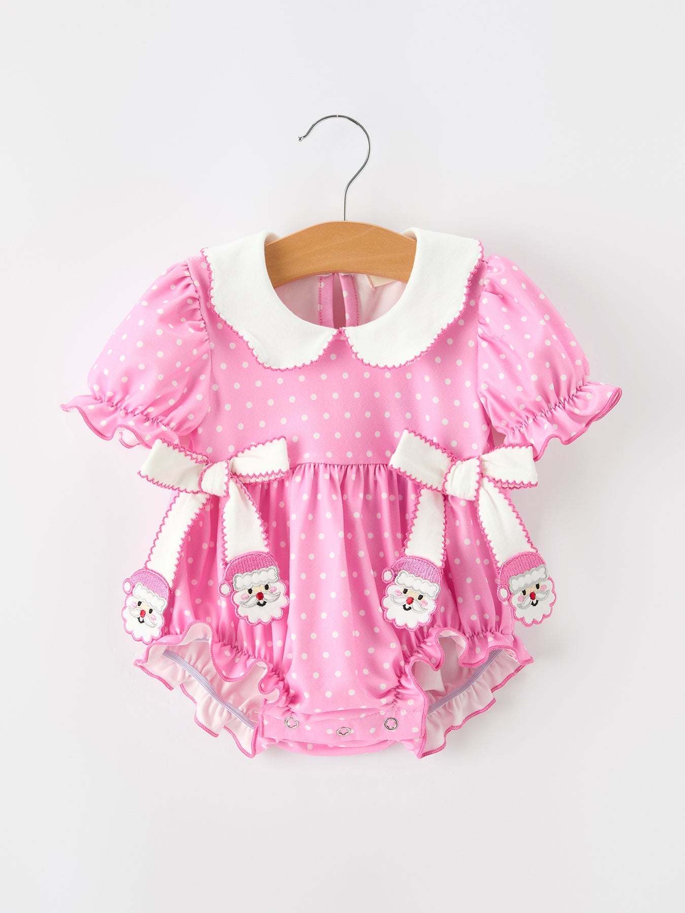 Baby girl bubble romper in pink and white polka dot with white Peter Pan collar, puff sleeves, ruffle trim and