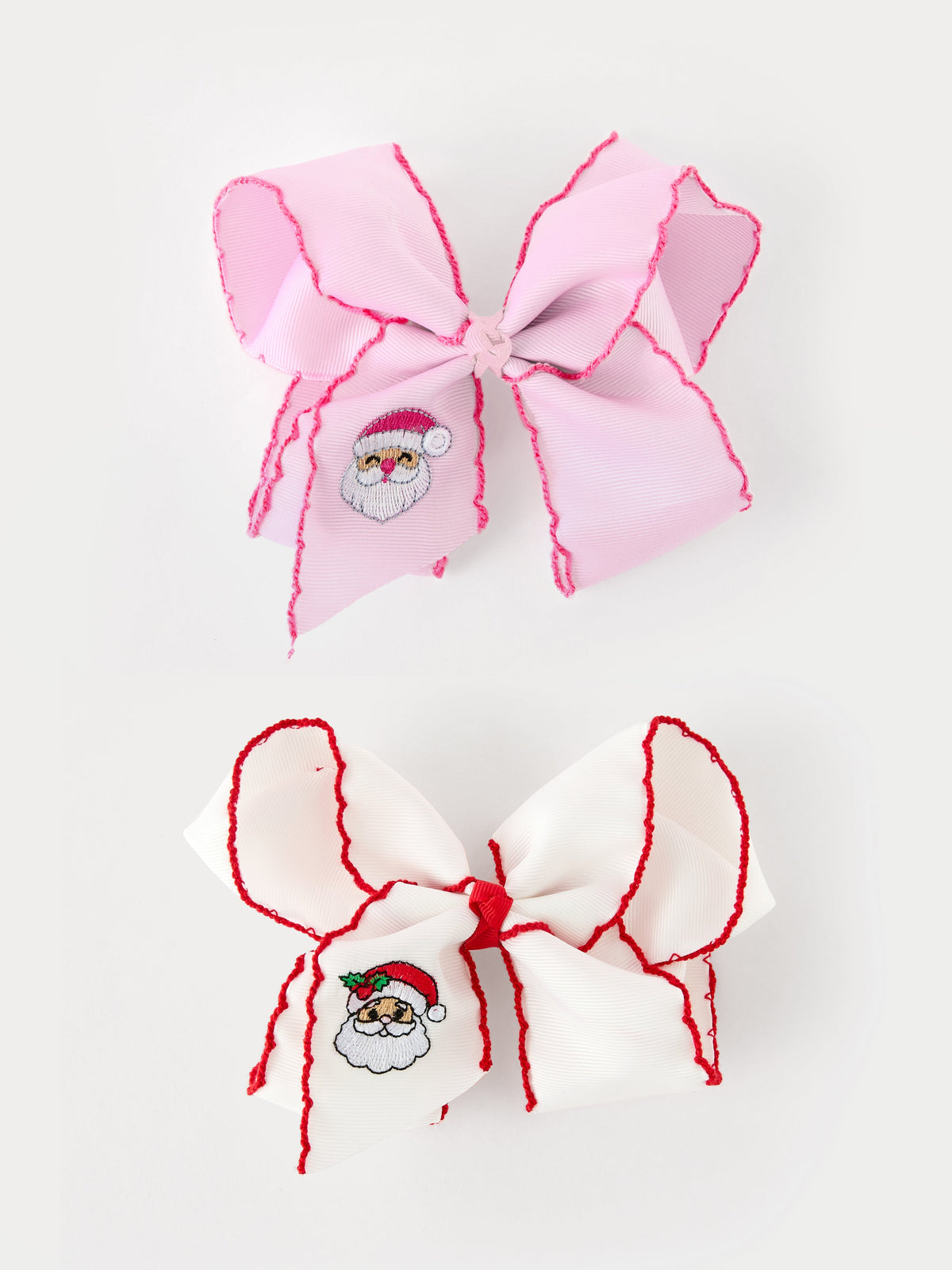 Large Christmas hair bow with embroidered Santa design and contrast stitched edges, shown in white and pink