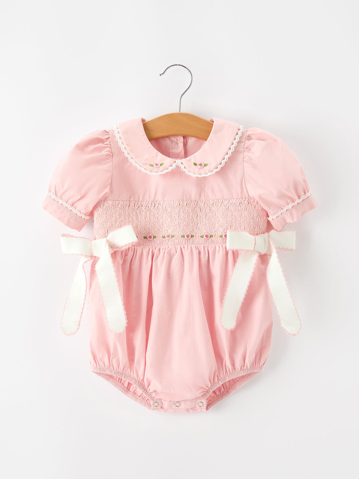 Pink floral embroidered baby bubble romper with smocked chest, lace-trimmed Peter Pan collar, puff sleeves and side bows
