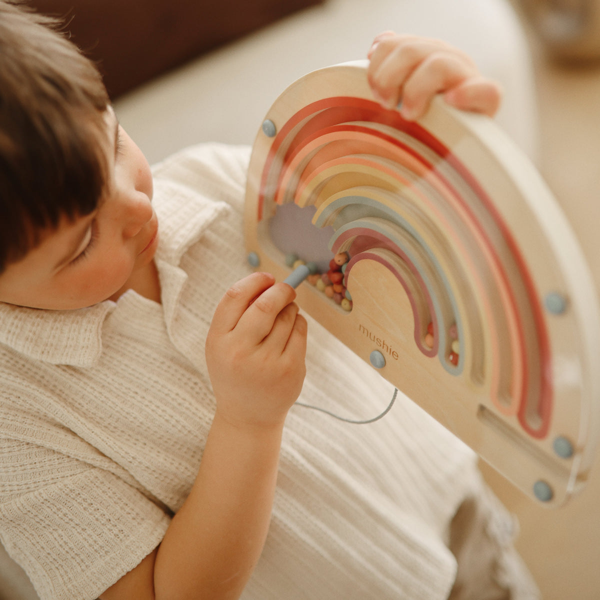 Mushie wooden magnetic rainbow maze, a vibrant educational toy for toddlers.