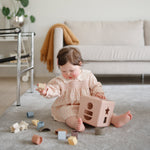 Mushie Shape Sorting Box, a natural baby learning toy.