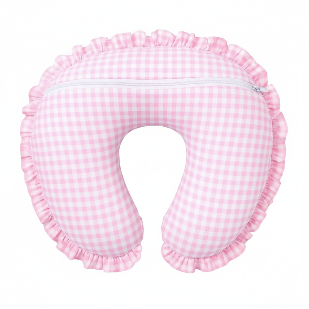 Soft pink gingham ruffle nursing pillow cover by Little Mae & Co, styled in a cozy baby nursery.