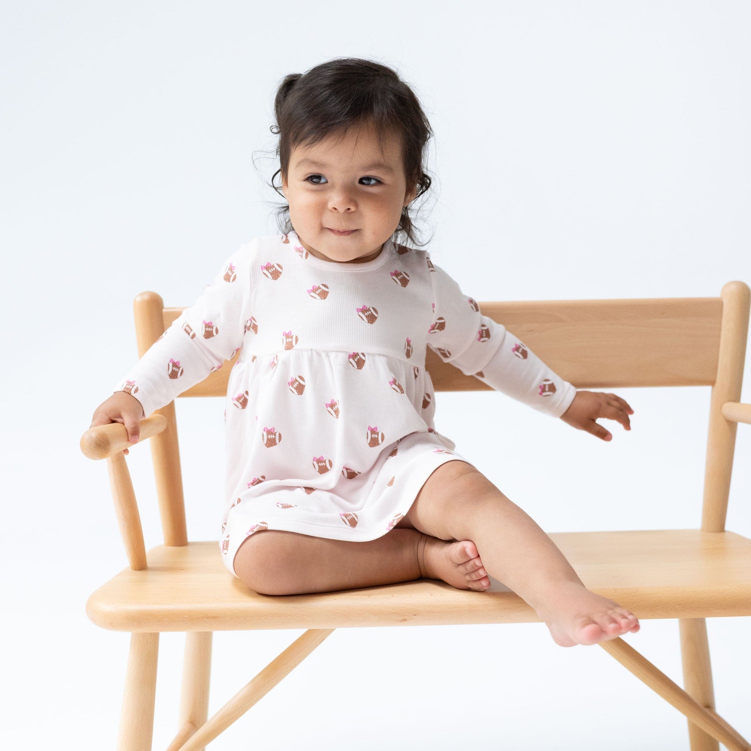 Baby dress and bloomer set in a mini football hearts print with a flowy skirt and matching bloomers.