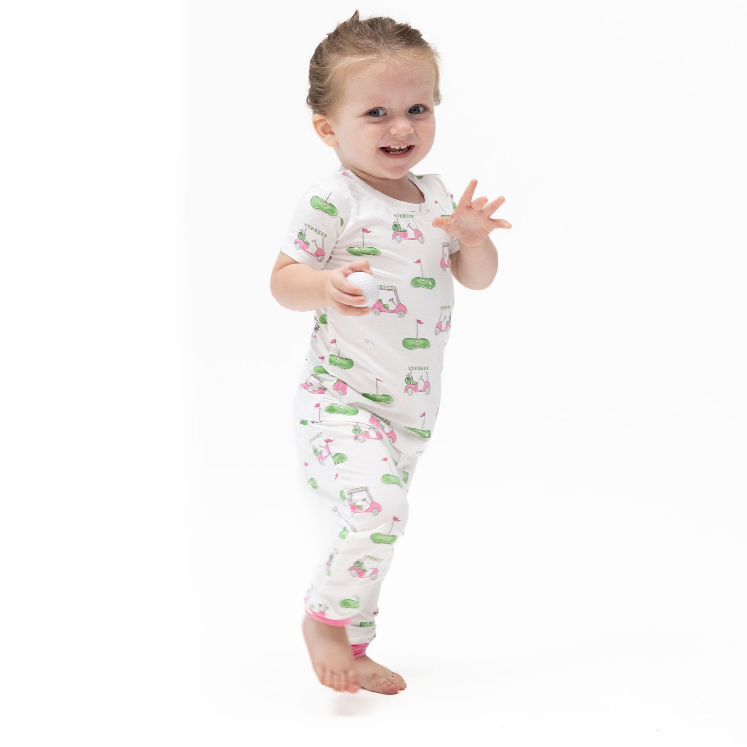 Two-piece short sleeve loungewear set with a pink golf cart print, short-sleeve top and matching pull-on pants.