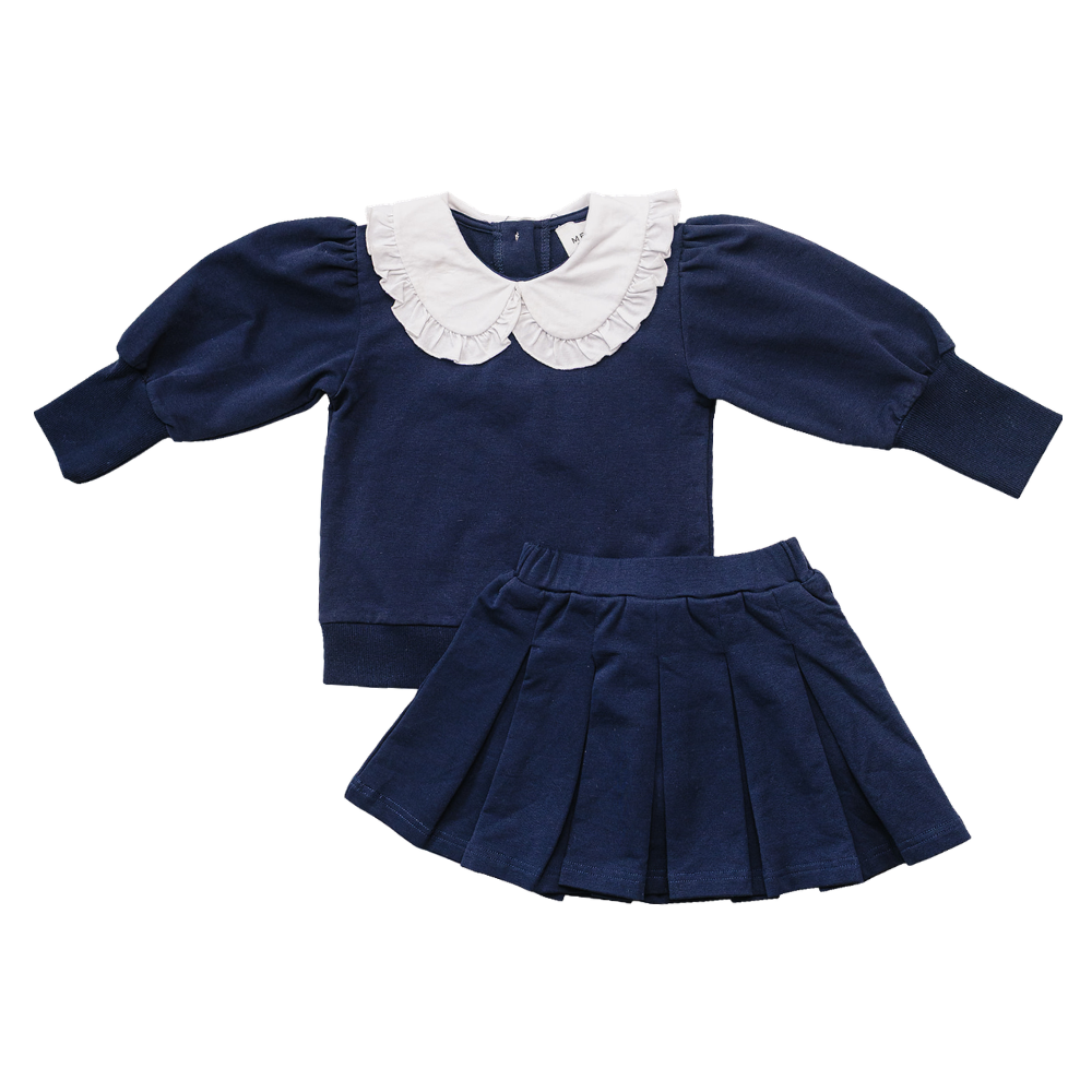 Navy long-sleeve top with puff sleeves and white frilled Peter Pan collar paired with a matching navy pleated skirt.