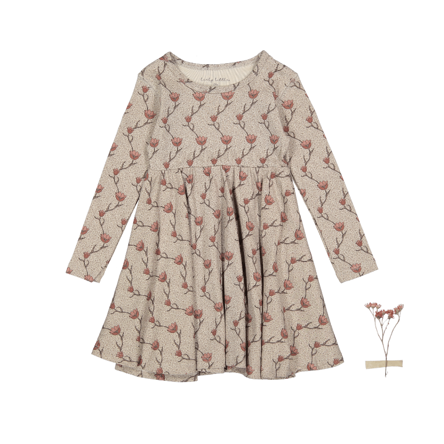 Young girl wearing a vibrant Iris print long sleeve dress, twirling happily in a sunny field.