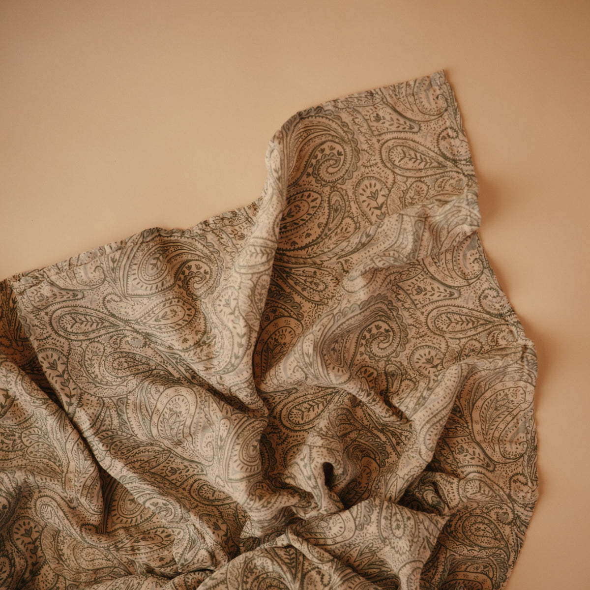 Mushie organic cotton muslin swaddle blanket, soft and breathable.