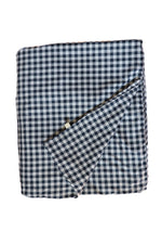 Little Mae & Co organic navy gingham quilted crib blanket draped over a white crib.