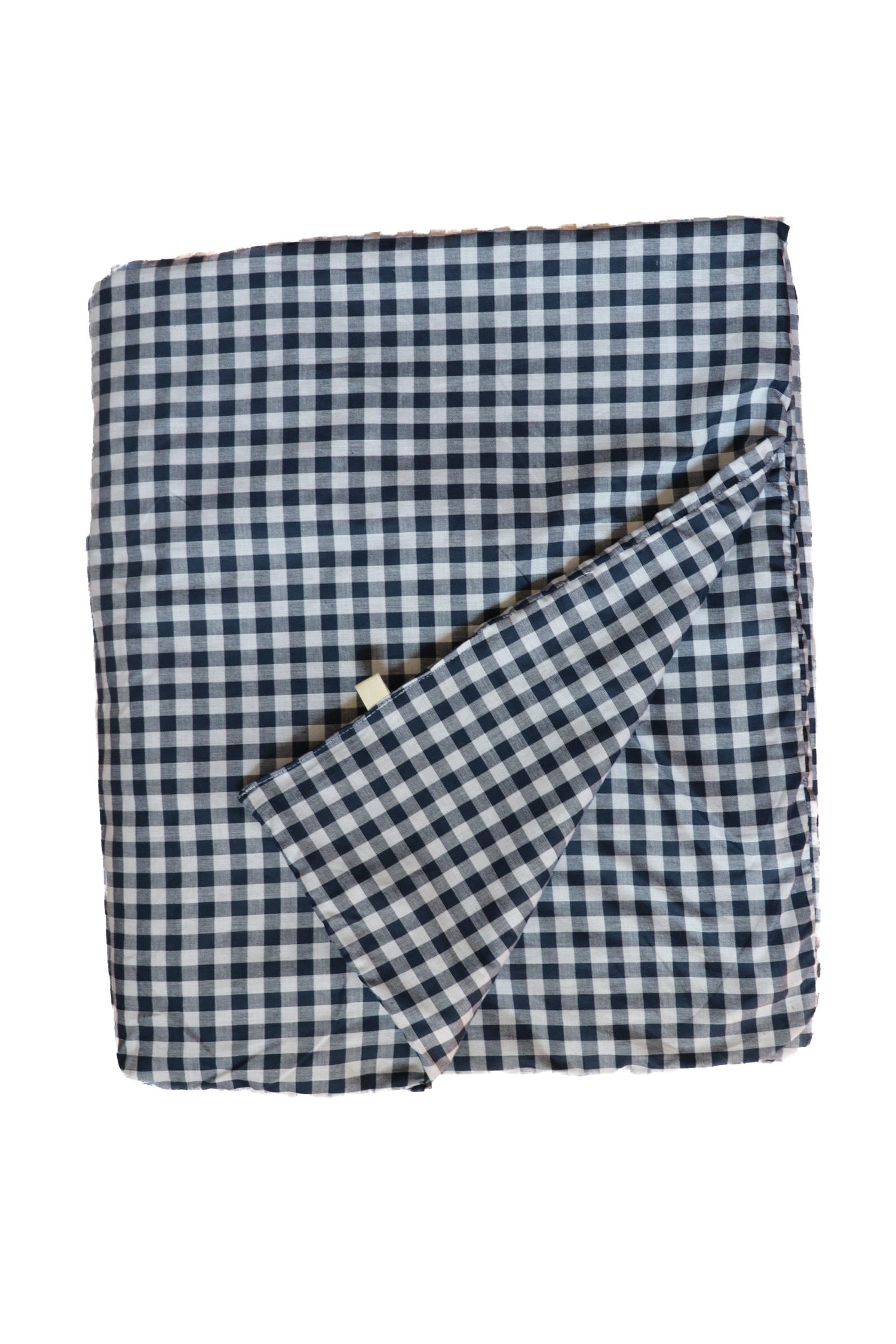 Little Mae & Co organic navy gingham quilted crib blanket draped over a white crib.