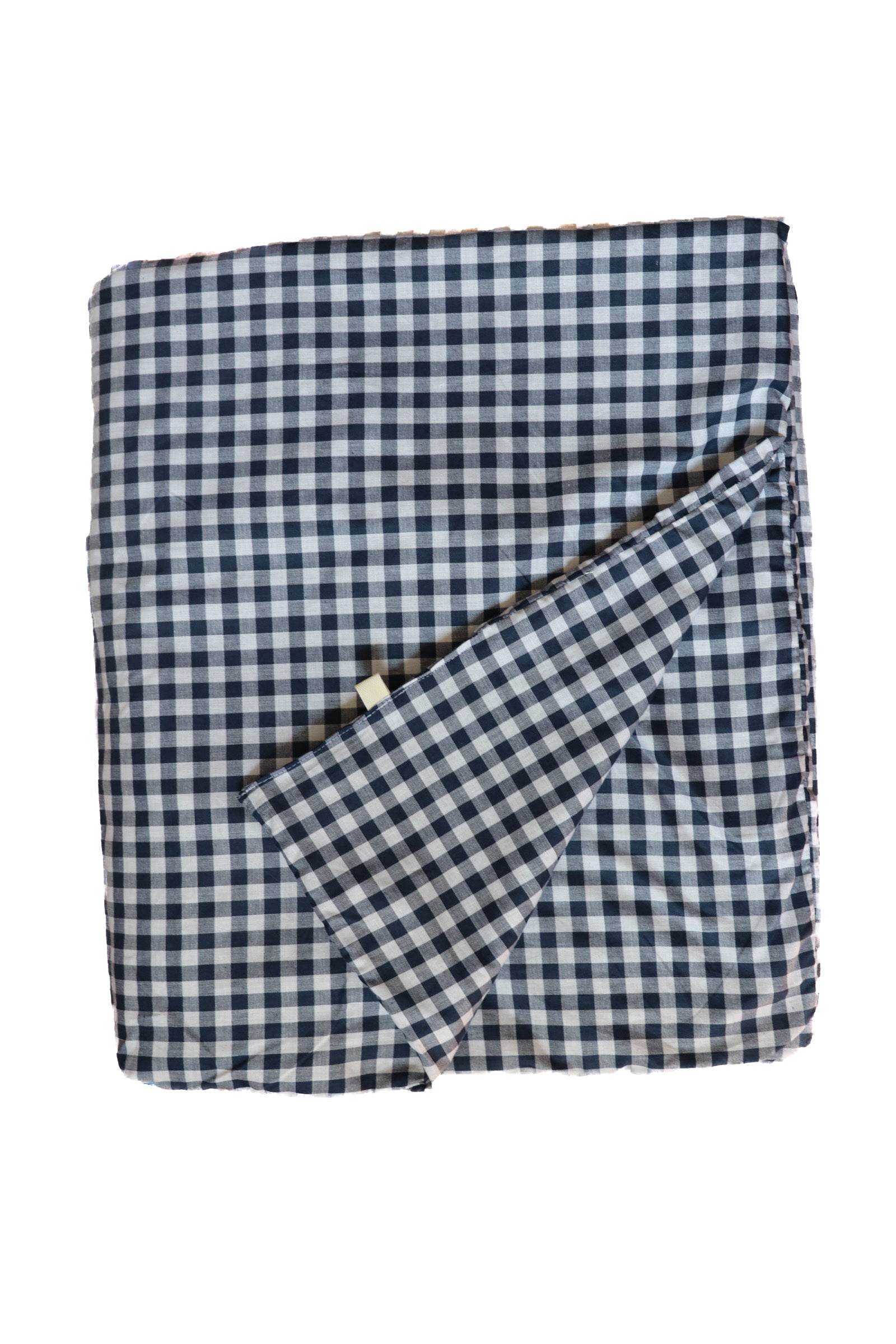 Little Mae & Co organic navy gingham quilted crib blanket draped over a white crib.