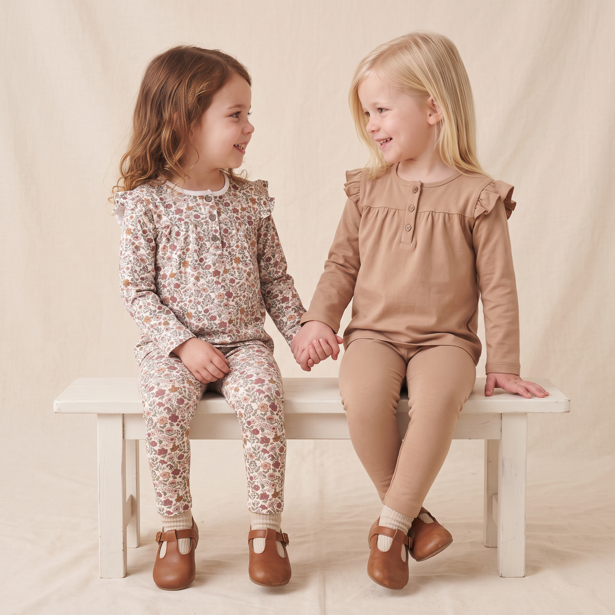 Two pairs of baby leggings, one in a woodland sprig print and one in solid taupe