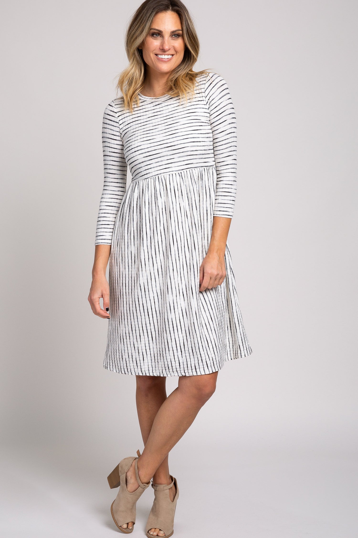 Ivory ribbed striped midi dress with pleated skirt, cinched waist, 3/4 sleeves and a rounded neckline.