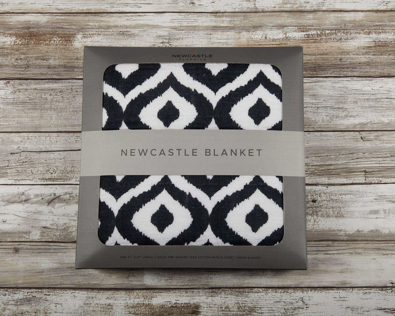 Newcastle Classics Moroccan Blue Cotton Muslin Blanket in packaging with black and white geometric pattern.