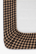 Cookie brown and white gingham pattern organic cotton crib sheet by Little Mae & Co for a baby's crib.