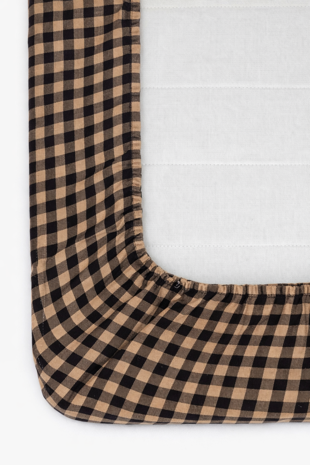 Cookie brown and white gingham pattern organic cotton crib sheet by Little Mae & Co for a baby's crib.