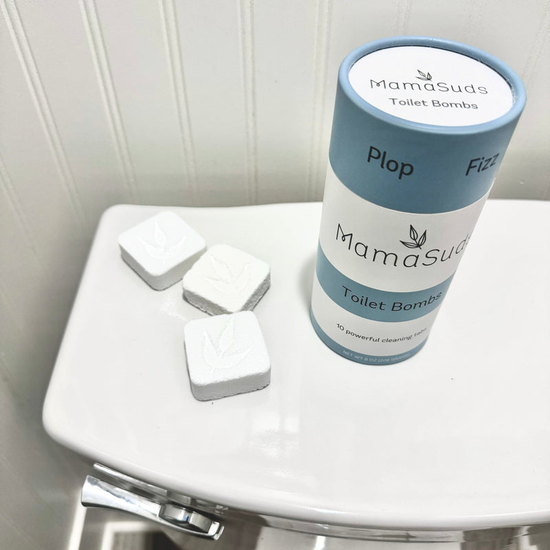 Non-toxic Toilet Bomb Cleaning Tabs on a toilet lid with packaging.