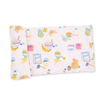 Pink swaddle blanket in the Breakfast Club print, spread out to show its square shape and border.