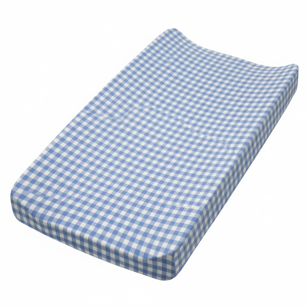 Little Mae & Co organic midnight blue gingham changing pad cover on a white changing pad in a nursery